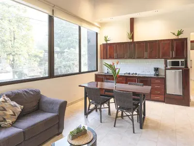a living room with a couch and a table at Surfside Apartments - Playa Carmen in Santa Teresa Beach