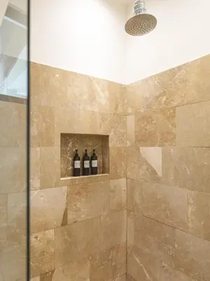 a shower with three bottles of wine on a shelf at Surfside Apartments - Playa Carmen in Santa Teresa Beach