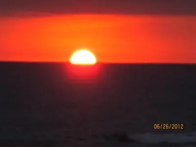 a sunset over the ocean with the sun in the sky at Hotel Arboleda in Quepos