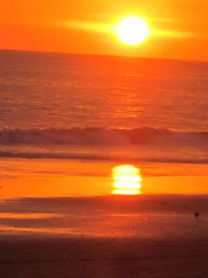 a sunset on the beach with the sun setting at Hotel Arboleda in Quepos