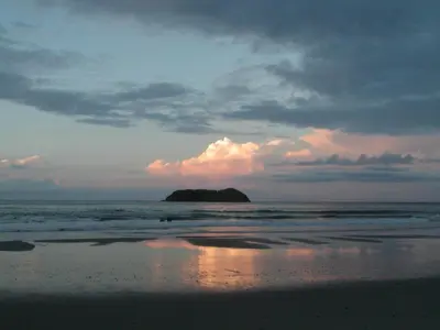 a view of a beach with a rock in the ocean at Hotel Arboleda in Quepos