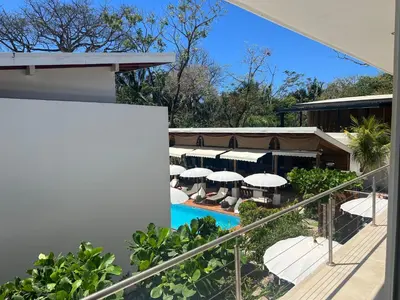 a view of a resort with a pool and umbrellas at Ride On! Surf Hotel in Nosara