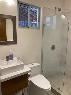 a bathroom with a toilet and a sink and a shower at Ride On! Surf Hotel in Nosara
