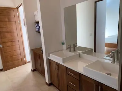 a bathroom with two sinks and a large mirror at Ride On! Surf Hotel in Nosara