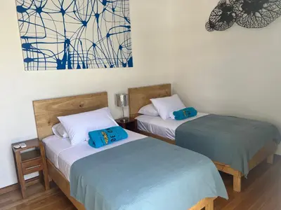 two beds sitting next to each other in a room at Ride On! Surf Hotel in Nosara