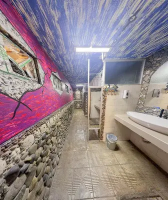 a bathroom with a painting on the wall at Costa Linda Art Hostel in Manuel Antonio