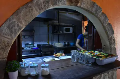 a kitchen with a person standing in the kitchen at Costa Linda Art Hostel in Manuel Antonio