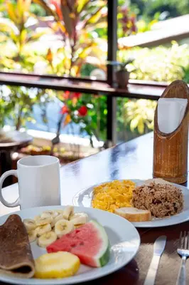 a plate of breakfast food on a table at Costa Linda Art Hostel in Manuel Antonio