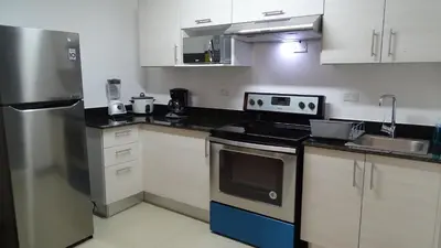 a kitchen with a refrigerator and a stove top oven at 3Room Penthouse Beach Condo in Jacó