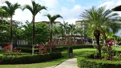 a park with palm trees and a building at 3Room Penthouse Beach Condo in Jacó
