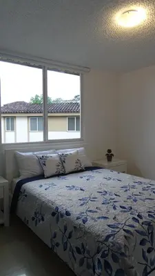 a bedroom with a bed and two large windows at 3Room Penthouse Beach Condo in Jacó