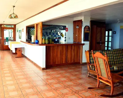 a kitchen and living room with a counter and chairs at Guayabo Lodge in Santa Cruz