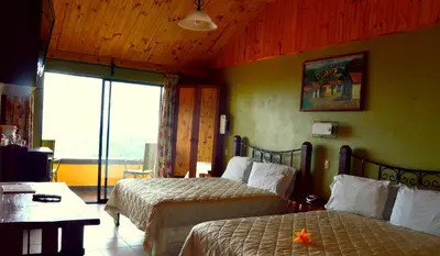 a hotel room with two beds and a window at Guayabo Lodge in Santa Cruz