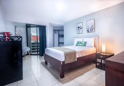 a hotel room with a bed and a balcony at Paradise Jaco Beach Front in Jacó