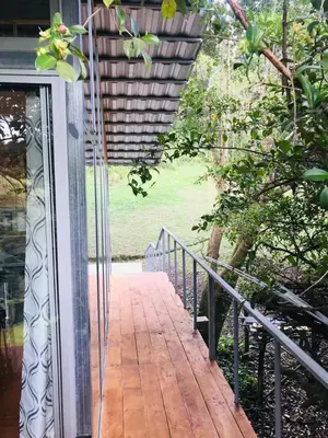 a glass door to a porch with a walkway at Cabaña treehouse Mountain View in San Isidro