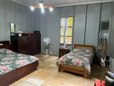 a bedroom with two beds and a fan at CASA TIPO QUINTA De ESPARCIMIENTO ANTIGUA TIPO VINTAG in Orotina