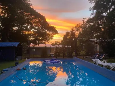 a swimming pool with a sunset in the background at CASA TIPO QUINTA De ESPARCIMIENTO ANTIGUA TIPO VINTAG in Orotina