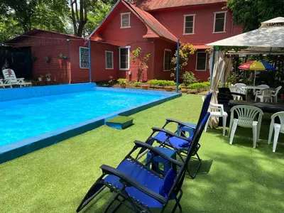 a yard with chairs and a swimming pool at CASA TIPO QUINTA De ESPARCIMIENTO ANTIGUA TIPO VINTAG in Orotina