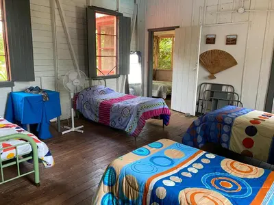 a room with three beds and a table in a room at CASA TIPO QUINTA De ESPARCIMIENTO ANTIGUA TIPO VINTAG in Orotina