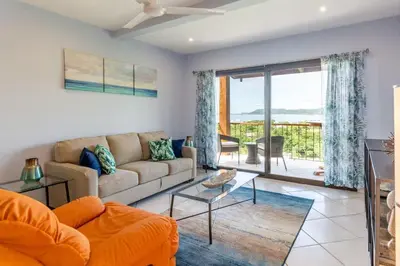 a living room with a couch and a table at Ocean-View 2-BD Condo with Pool in Playa Flamingo