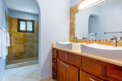 a bathroom with a double sink and a shower at Ocean-View 2-BD Condo with Pool in Playa Flamingo