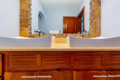 a bathroom with two sinks and a large mirror at Ocean-View 2-BD Condo with Pool in Playa Flamingo