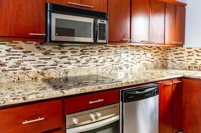 a kitchen with a microwave and a stove top oven at Ocean-View 2-BD Condo with Pool in Playa Flamingo