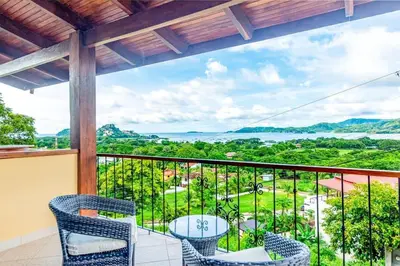 a balcony with chairs and a view of the ocean at 2-BD with Ocean-View Terrace and Pool in Playa Flamingo