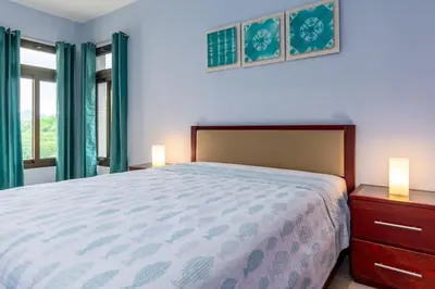 a bedroom with a bed and two lamps on night stands at 2-BD with Ocean-View Terrace and Pool in Playa Flamingo