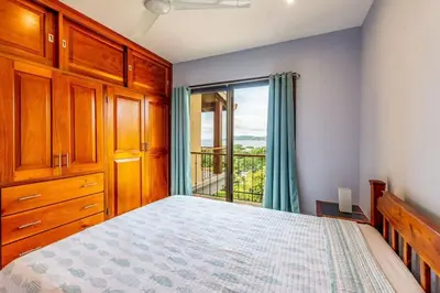 a bedroom with a bed and a large window at 2-BD with Ocean-View Terrace and Pool in Playa Flamingo