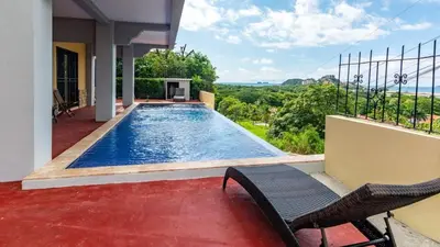 a swimming pool in the backyard of a house at 2-BD with Ocean-View Terrace and Pool in Playa Flamingo