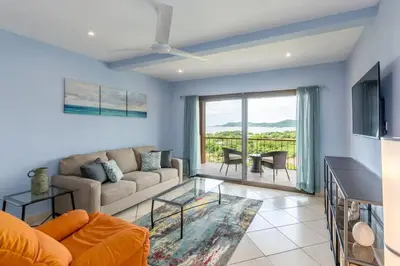 a living room with a couch and a table at 2-BD with Ocean-View Terrace and Pool in Playa Flamingo