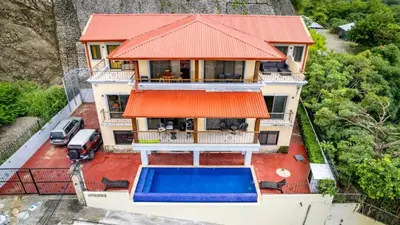 an aerial view of a house with a swimming pool at 2-BD with Ocean-View Terrace and Pool in Playa Flamingo