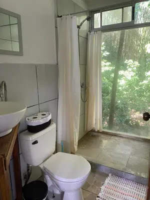a bathroom with a toilet and a sink and a window at Nahele Lodge in Santa Teresa Beach