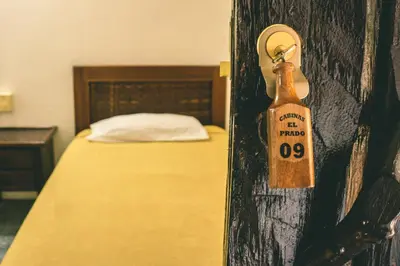 a bedroom with a bed with a bottle on the wall at Cabinas EL PRADO in San Isidro