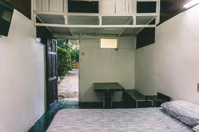 an empty room with a bed and a table at Cabinas EL PRADO in San Isidro