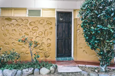 a house with a wall with a door at Cabinas EL PRADO in San Isidro