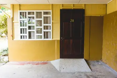 a door on a yellow building with a window at Cabinas EL PRADO in San Isidro
