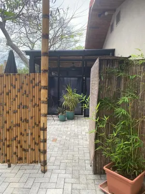 a fence with potted plants in front of a house at Bungle in the Jungle in Playa Panama
