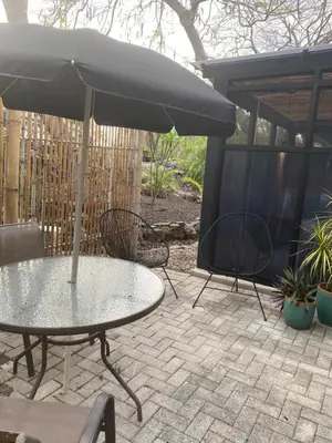 a table and chairs with an umbrella on a patio at Bungle in the Jungle in Playa Panama