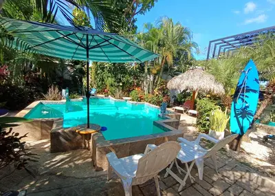 a pool with a table and chairs and an umbrella at Suite Paraiso Azul in Tamarindo