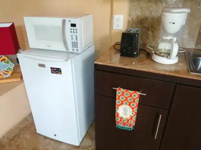 a microwave on top of a refrigerator in a kitchen at Suite Paraiso Azul in Tamarindo