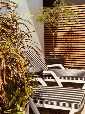 a white bench sitting next to potted plants at Hotel Daleese in Uvita