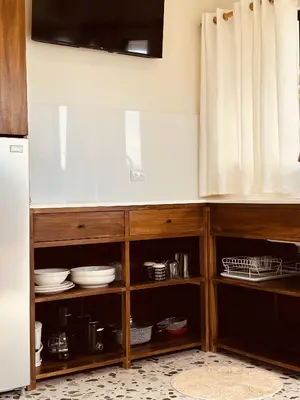 a kitchen with wooden cabinets with plates and dishes at Hotel Daleese in Uvita