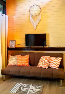 a brown couch with pillows in a living room at Coyote Rooms in Cabuya
