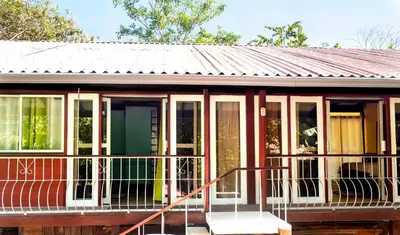 a small house with a metal roof at Coyote Rooms in Cabuya