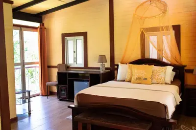 a bedroom with a bed and a desk and a mirror at Coyote Rooms in Cabuya