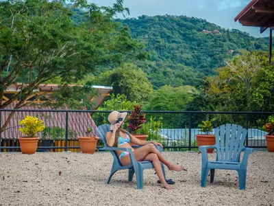 a woman sitting on a chair talking on a cell phone at Hotel Amira in Carrillo