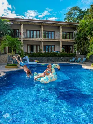two people on inflatables in a swimming pool at Hotel Amira in Carrillo