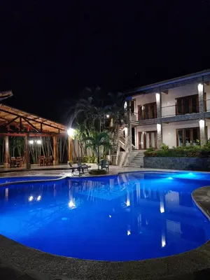 a large blue swimming pool at night at Hotel Amira in Carrillo